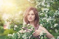 Lifestyle portrait of beautiful girl in spring blossom garden. Beauty woman on apple flowers and green leaves background Royalty Free Stock Photo