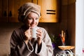 Lifestyle portrait of a beautiful young girl drinking morning coffee in her kitchen Royalty Free Stock Photo