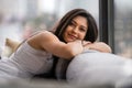 Lifestyle portrait of a beautiful young indian woman, relaxing at home in urban apartment