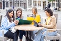 Lifestyle portrait of a diverse multiethnic group of four young smiling businesswomen with smartphones, notes and Royalty Free Stock Photo