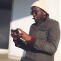 Lifestyle portrait fashion young african man using smartphone Royalty Free Stock Photo