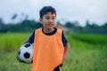 Lifestyle portrait of handsome and happy young boy holding soccer ball playing football outdoors at green grass field smiling chee Royalty Free Stock Photo