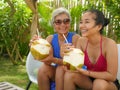Lifestyle portrait of happy and beautiful Asian Indonesian teenager girl enjoying Summer holidays drinking coconut at tropical Royalty Free Stock Photo