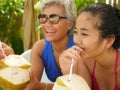 Lifestyle portrait of happy and beautiful Asian Indonesian teenager girl enjoying Summer holidays drinking coconut at tropical Royalty Free Stock Photo