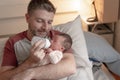 Lifestyle portrait of proud happy man holding tenderly bottle feeding her child - an adorable and beautiful newborn baby girl in Royalty Free Stock Photo