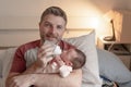 Lifestyle portrait of proud happy man holding tenderly bottle feeding her child - an adorable and beautiful newborn baby girl in Royalty Free Stock Photo