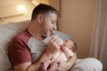 Lifestyle portrait of proud happy man holding tenderly bottle feeding her child - an adorable and beautiful newborn baby girl in Royalty Free Stock Photo