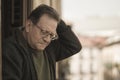 Lifestyle portrait of sad and depressed mature man 65 to 70 years old at home balcony feeling lonely and confused facing getting Royalty Free Stock Photo