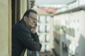 Lifestyle portrait of sad and depressed mature man 65 to 70 years old at home balcony feeling lonely and confused facing getting Royalty Free Stock Photo