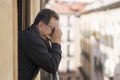 Lifestyle portrait of sad and depressed mature man 65 to 70 years old at home balcony feeling lonely and confused facing getting Royalty Free Stock Photo