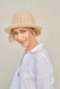 Lifestyle portrait of tricky woman in white shirt and straw hat