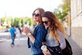 Lifestyle portrait of two happy friend girls walk laugh talk and drink lemonade wearing trendy bright clothes and sunglasses.Girls