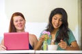 Young happy and beautiful caucasian and latin women working at office cafe with laptop computer discussing as digital business Royalty Free Stock Photo