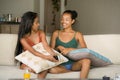 Lifestyle portrait of two young happy and relaxed Asian girlfriends having fun talking laughing and gossiping at home sofa couch s Royalty Free Stock Photo