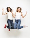 Lifestyle portrait of two young hipster girls best friends jump Royalty Free Stock Photo