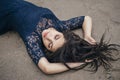 Lifestyle portrait of a woman brunette on background of the lake lying in sand on a cloudy day. Romantic, gentle, mystical Royalty Free Stock Photo