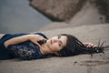 Lifestyle portrait of a woman brunette on background of the lake lying in sand on a cloudy day. Romantic, gentle, mystical Royalty Free Stock Photo