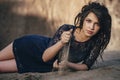 Lifestyle portrait of a woman brunette on background of the lake lying in sand on a cloudy day. Romantic, gentle, mystical Royalty Free Stock Photo