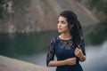 Lifestyle portrait of a woman brunette on the background of the lake in the sand on a cloudy day. Romantic, gentle, mystical