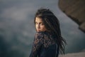 Lifestyle portrait of a woman brunettes in background of lake sitting in sand on a cloudy day. Romantic, gentle, mystical Royalty Free Stock Photo