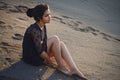 Lifestyle portrait of a woman brunettes in background of lake sitting in sand on a cloudy day. Romantic, gentle, mystical Royalty Free Stock Photo