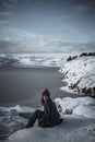 Lifestyle portrait of woman cuddled up in blanket looking into camera and enjoying amazing sunny winter day in Scandinavia.