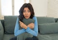 Portrait of a young woman looking scared and shocked watching scary movie on TV Royalty Free Stock Photo