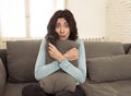 Portrait of a young woman looking scared and shocked watching scary movie on TV Royalty Free Stock Photo