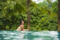 Lifestyle portrait of young attractive and beautiful Asian Chinese woman relaxing happy at tropical beach resort swimming at hotel Royalty Free Stock Photo