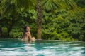Lifestyle portrait of young attractive and beautiful Asian Chinese woman relaxing happy at tropical beach resort swimming at hotel Royalty Free Stock Photo