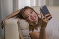 Young attractive happy and relaxed student Asian woman enjoying homey lying at living room sofa couch using internet social media Royalty Free Stock Photo