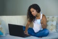 Young attractive and relaxed black african American student woman sitting at home sofa couch networking with laptop computer drink Royalty Free Stock Photo