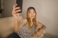 Lifestyle portrait of young attractive and relaxed 30s Asian Indonesian woman lying comfortable with mobile phone at home living Royalty Free Stock Photo