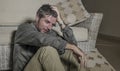 Lifestyle portrait young attractive sad and depressed man sitting on living room floor feeling desperate and stressed suffering Royalty Free Stock Photo