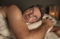 Lifestyle portrait of young attractive scared and paranoid man lying in bed having  bad dreams and nightmares looking around in Royalty Free Stock Photo