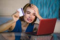 Lifestyle portrait of young attractive and upset woman at home couch checking finance with credit card and laptop computer worried Royalty Free Stock Photo