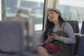 Lifestyle portrait of young beautiful and attractive Asian Korean woman in winter hat looking thoughtful through window on train Royalty Free Stock Photo