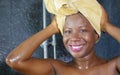 Lifestyle portrait of young beautiful black African American woman having a shower with her head wrapped in a towel smiling Royalty Free Stock Photo