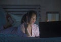 Lifestyle portrait of young beautiful and happy Asian Chinese student girl watching online movie or enjoying social media with Royalty Free Stock Photo
