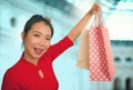 Lifestyle portrait of young beautiful and happy Asian Korean woman holding shopping bags at modern shopping mall smiling excited Royalty Free Stock Photo