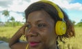 Young beautiful and happy black afro American woman with headset listening to music outdoors chilled and relaxed enjoying summer Royalty Free Stock Photo
