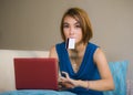 Lifestyle portrait of young beautiful and happy girl at home living room holding credit card using laptop computer for banking an Royalty Free Stock Photo