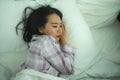 Lifestyle portrait of young beautiful and sweet Asian Chinese girl on her 20s alone at home sleeping relaxed wearing pajamas lying Royalty Free Stock Photo