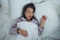 Lifestyle portrait of young beautiful and sweet Asian Chinese girl on her 20s alone at home sleeping relaxed wearing pajamas lying Royalty Free Stock Photo