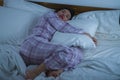 Lifestyle portrait of young beautiful and sweet Asian Chinese girl on her 20s alone at home sleeping relaxed wearing pajamas lying Royalty Free Stock Photo