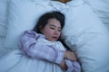 Lifestyle portrait of young beautiful and sweet Asian Korean girl on her 20s alone at home sleeping relaxed wearing pajamas lying Royalty Free Stock Photo