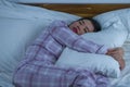 Lifestyle portrait of young beautiful and sweet Asian Korean girl on her 20s alone at home sleeping relaxed wearing pajamas lying Royalty Free Stock Photo