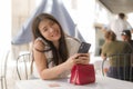 Lifestyle portrait of young beautiful and sweet Asian Korean woman sitting happy outdoors at street cafe using internet travel and Royalty Free Stock Photo