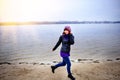 Lifestyle portrait of young Caucasian slim woman runs along beach autumn Royalty Free Stock Photo