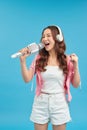 Lifestyle portrait of young cute and happy Asian student girl singing online karaoke song with microphone Royalty Free Stock Photo